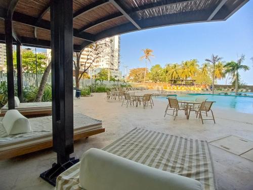 a resort patio with tables and chairs and a pool at Exclusive Apartasuites Reserva del Mar ツ in Gaira