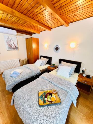 Zimmer mit 2 Betten und einem Tablett mit Essen in der Unterkunft Salaš kod Bobana in Bač