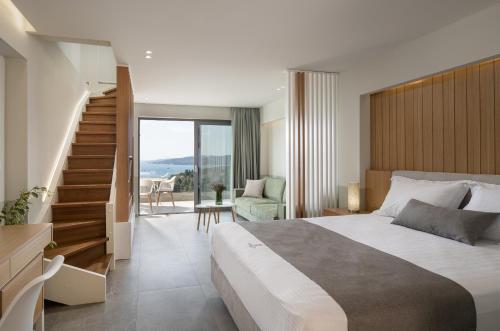 - une chambre avec un grand lit et un escalier dans l'établissement Exclusive Villas Pappas, à Sarti