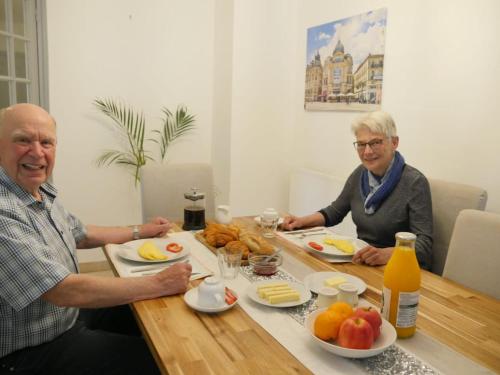dos personas mayores sentadas en una mesa con comida en Private ROOM, en Montpellier