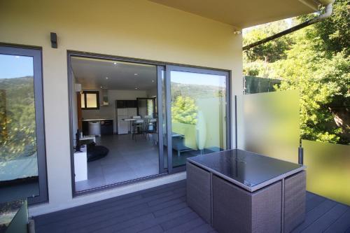 a balcony with sliding glass doors and a dining area at Apartamento Javali - Casas Barca do Rio by Gerês Casas in Geres