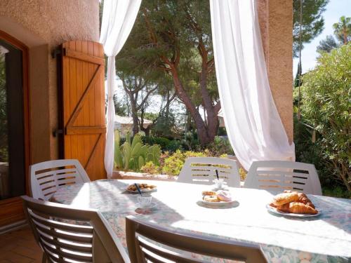 - une table et des chaises sur une terrasse avec de la nourriture dans l'établissement Maison familiale sous les palmiers de Hyères, à Hyères