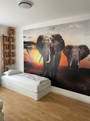 a bedroom with a mural of two elephants on the wall at Joanna Apartment - MA Käfertal 1 in Mannheim
