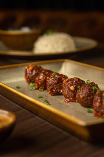 a plate of food with meat on a table at 37th Crescent Hotel Bengaluru in Bengaluru