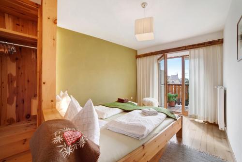 1 dormitorio con cama y ventana grande en Ferienwohnungen Zwick Maroles, en Malles Venosta