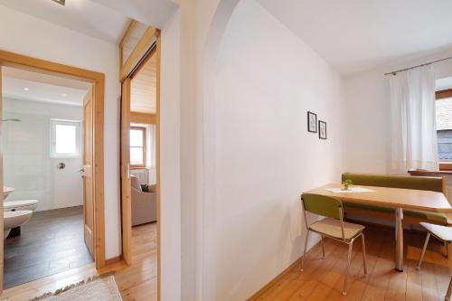 a room with a dining table and a bathroom at Ferienwohnungen Zwick Maroles in Malles Venosta