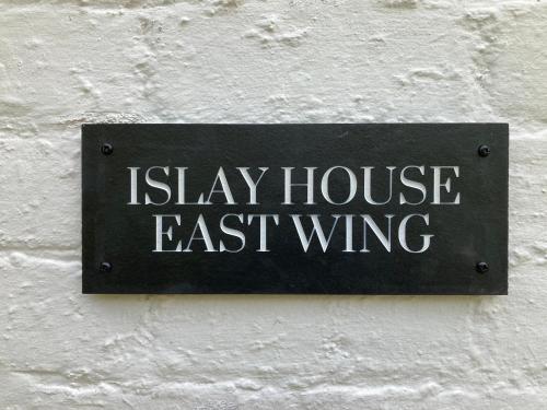 Pencaitland的住宿－ISLAY House,Comfortable Home with private garden, Pencaitland, East Lothian, Scotland，墙上的标志,上面写着“留在房子东侧”
