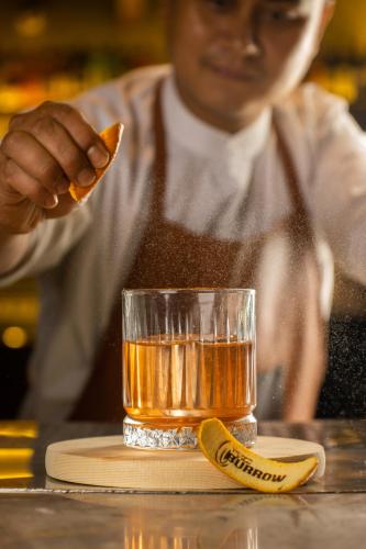 a man eating a piece of food next to a glass of tea at 37th Crescent Hotel Bengaluru in Bengaluru