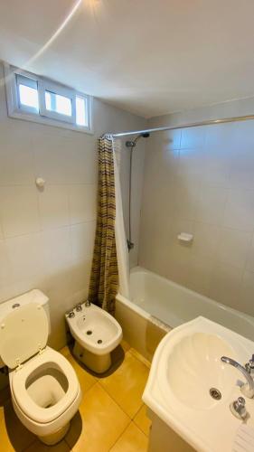 a bathroom with a toilet and a sink and a tub at Cornejo Temporarios in Salta