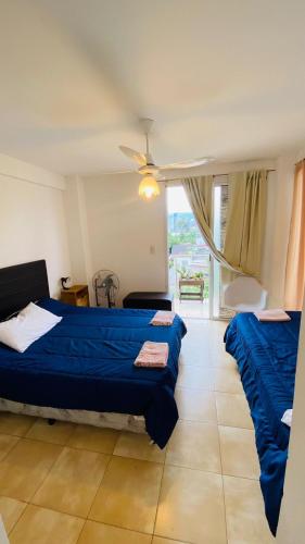 a bedroom with two beds and a large window at Cornejo Temporarios in Salta