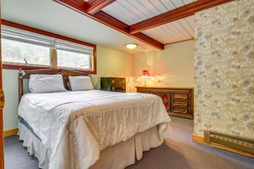 1 dormitorio con 1 cama grande y ventana en Secluded Holter Lake Vacation Rental with Deck!, 