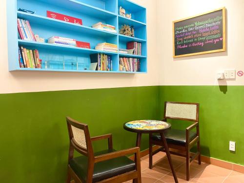 a table and chairs in a room with bookshelves at Ahu Hotel & Apartment in Ho Chi Minh City