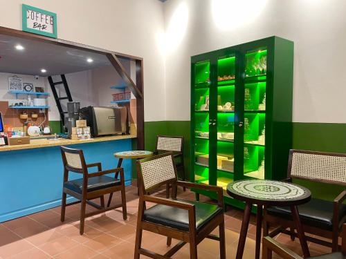 un restaurante con mesas y sillas y un armario verde en Ahu Hotel & Apartment, en Ho Chi Minh
