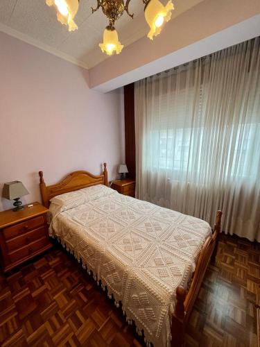 a bedroom with a bed and a large window at Piso en pleno centro de Miño derecha in Miño