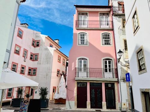 a group of pink buildings in a street at Casa Rosa com AC in Coimbra