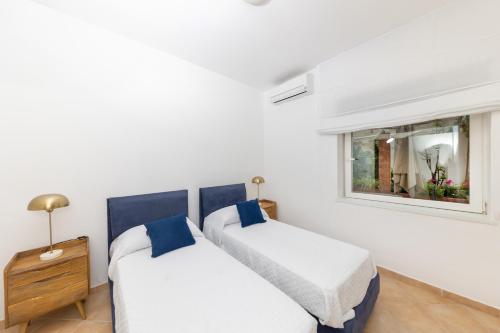 2 camas en una habitación blanca con ventana en Birago22Capri, en Capri