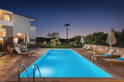 コリンバリにあるVilla Tranquillaのラウンジチェアとパラソル付きのプールが隣接しています。