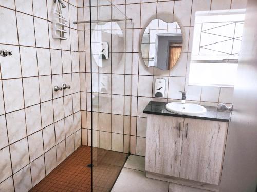 a bathroom with a sink and a mirror at Tramonto Lodge in Upington