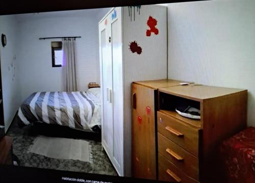 a small bedroom with a bed and a dresser with a dresser at Casa Tía Daniela in Casas de Millán