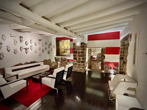 a living room with a piano and white chairs at Casa Cartagena Boutique Hotel & Spa in Cusco