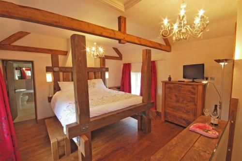 Schlafzimmer mit Himmelbett und Kronleuchter in der Unterkunft Heather Cottage in Kirk Ireton