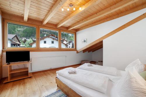 a bedroom with two beds and a flat screen tv at Ferienwohnungen Zwick Valarga in Burgusio