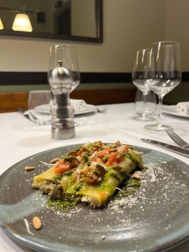 a slice of pizza on a plate on a table at Hostal de la Plaça - Hotel Boutique in Cabrils