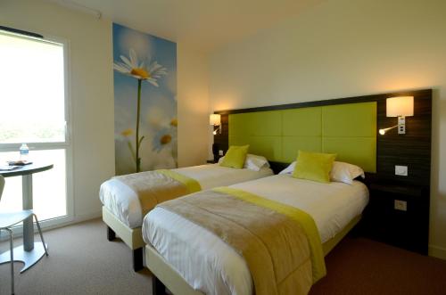 2 Betten in einem Hotelzimmer mit einer Blume an der Wand in der Unterkunft Hôtel la Verriaire - The Originals in La Verrie