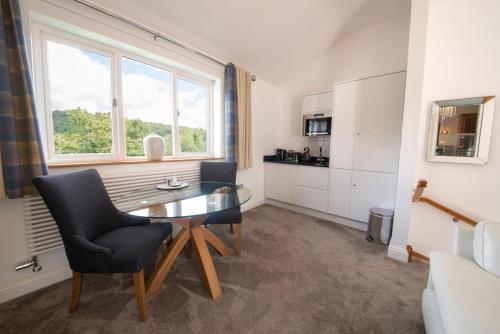 a living room with a table and a kitchen at Hawkshead Suites in Hawkshead
