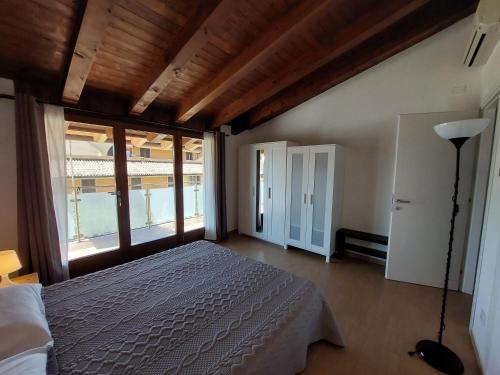 a bedroom with a bed and a large window at Pizzocolo resort fasano in Gardone Riviera