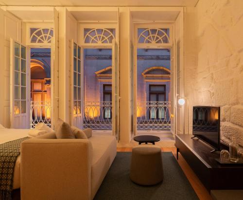 a living room with a bed and a fireplace at d'ALMA Boutique Hotel in Porto