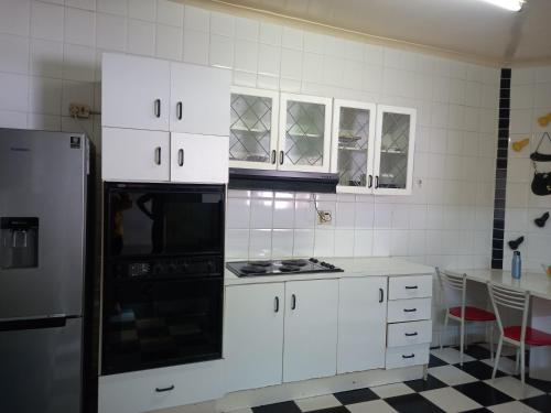 a kitchen with white cabinets and a stove top oven at Guest Houses Great choice in Cape Town