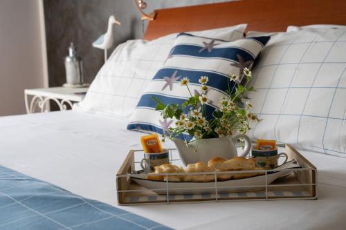 een dienblad met brood en bloemen op een bed bij Il Nido di Jonathan Livingstone in Rapallo