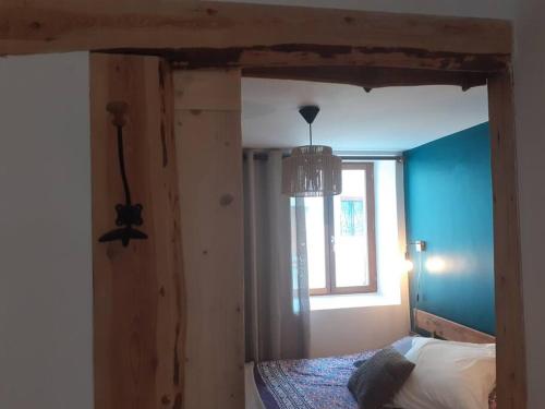 sypialnia z łóżkiem z oknem i żyrandolem w obiekcie Chamalières Sur Loire : Un superbe appartement w mieście Chamalières-sur-Loire