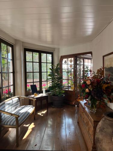 a living room with a couch and a table with flowers at Hostal de la Plaça - Hotel Boutique in Cabrils