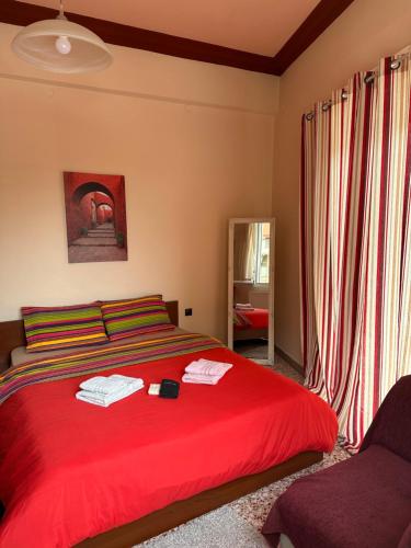 een slaapkamer met een rood bed en een raam bij Capital apartment next to Metro station with parking spot to explore Athens in Athene