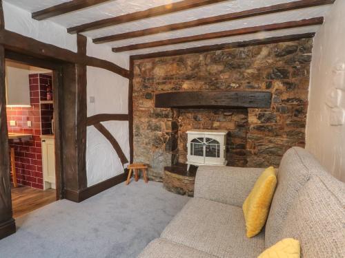 a living room with a couch and a stone fireplace at The Coach House in Holywell