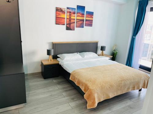 a bedroom with a large bed and two night stands at DXN Luxury Apartment 5 in Năvodari