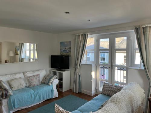 a living room with a couch and a tv at Beau retreat lovely apartment in Beaumaris in Beaumaris