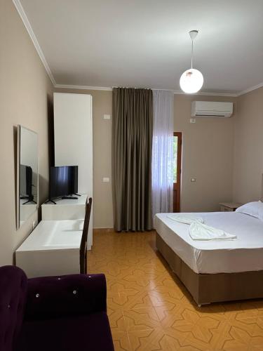 1 dormitorio con cama, bañera y TV en Molla Hotel Restorant en Shëngjin