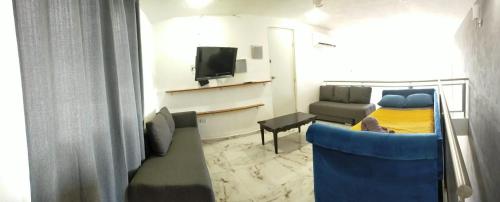a room with a couch and a bed and a tv at Loft Solimán - Netflix - HBO - Near Market 28 - Downtown in Cancún