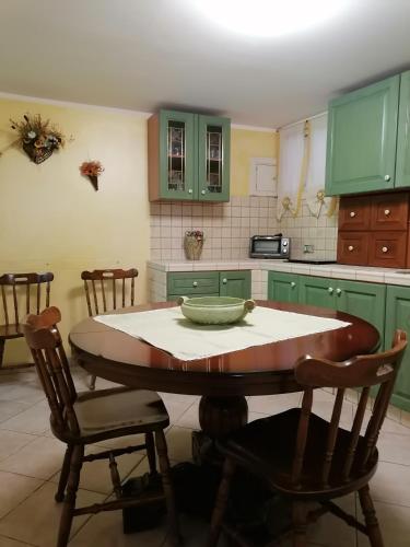 een keuken met groene kasten en een tafel en stoelen bij Apartment Maria in Enna
