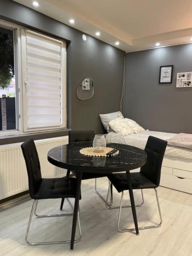 Pokój ze stołem, krzesłami i łóżkiem w obiekcie Beta House Apartments w mieście Zaječar