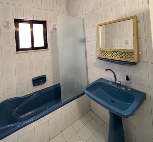 ein Badezimmer mit einem blauen Waschbecken und einem Spiegel in der Unterkunft Crafthouse in Amman