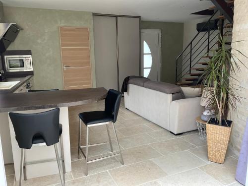 a kitchen with a table and chairs and a couch at LOGIS DU FAUBOURG petite maison de charme, tranquille, calme et lumineuse in Val-de-Mercy