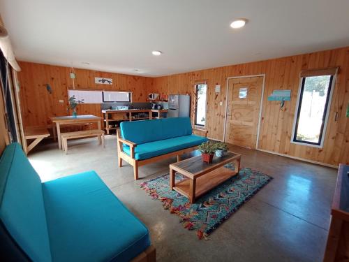 ein Wohnzimmer mit einem blauen Sofa und einem Tisch in der Unterkunft 7 Olas lodge in Algarrobo