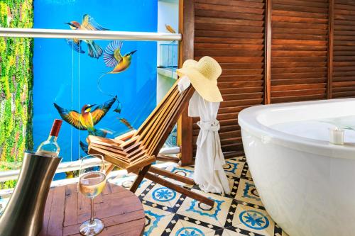 a bathroom with a tub and a chair and a glass of wine at Soul Beach Boutique Hotel & Spa in Playa del Carmen
