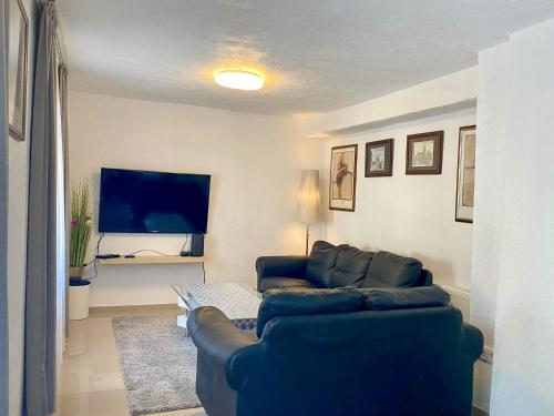 uma sala de estar com um sofá azul e uma televisão de ecrã plano em Ferienhaus Dakaj - Einfamilienhaus em Trier