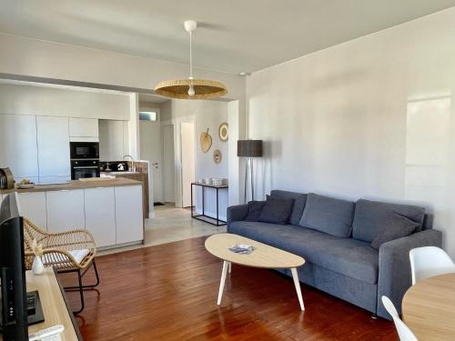 un salon avec un canapé bleu et une table dans l'établissement Maison front de mer 8 pers Soulac sur Mer, à Soulac-sur-Mer