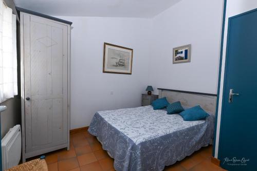 サン・ジル・クロワ・ド・ヴィにあるGÎTE DES FRUCHESのベッドルーム(青い枕のベッド1台付)